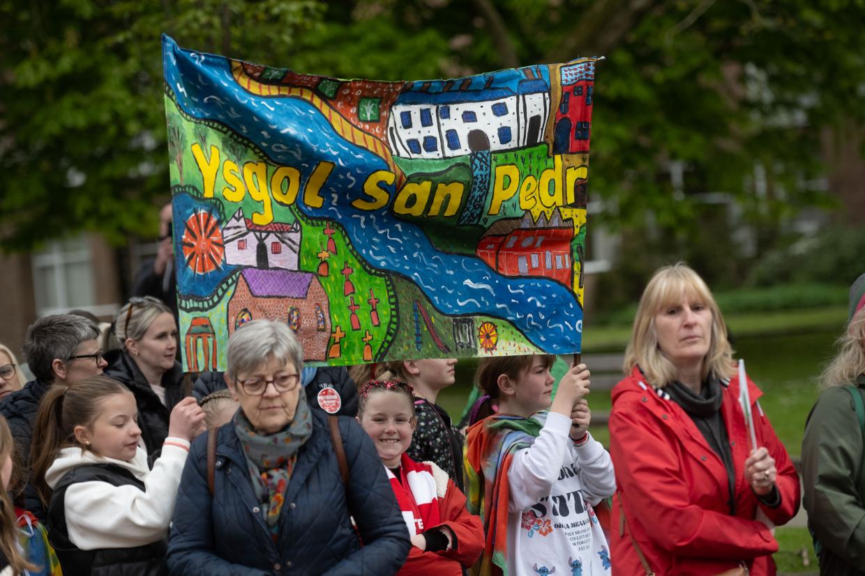 Baner liwgar un o'r ysgolion yn gorymdeithio yn ystod Cyhoeddi Eisteddfod 2025