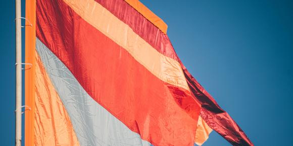 Colourful orange banner against a blue sky