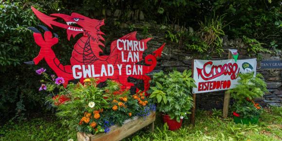 Celf i groesawu pobl i'r Eisteddfod gyda draig goch