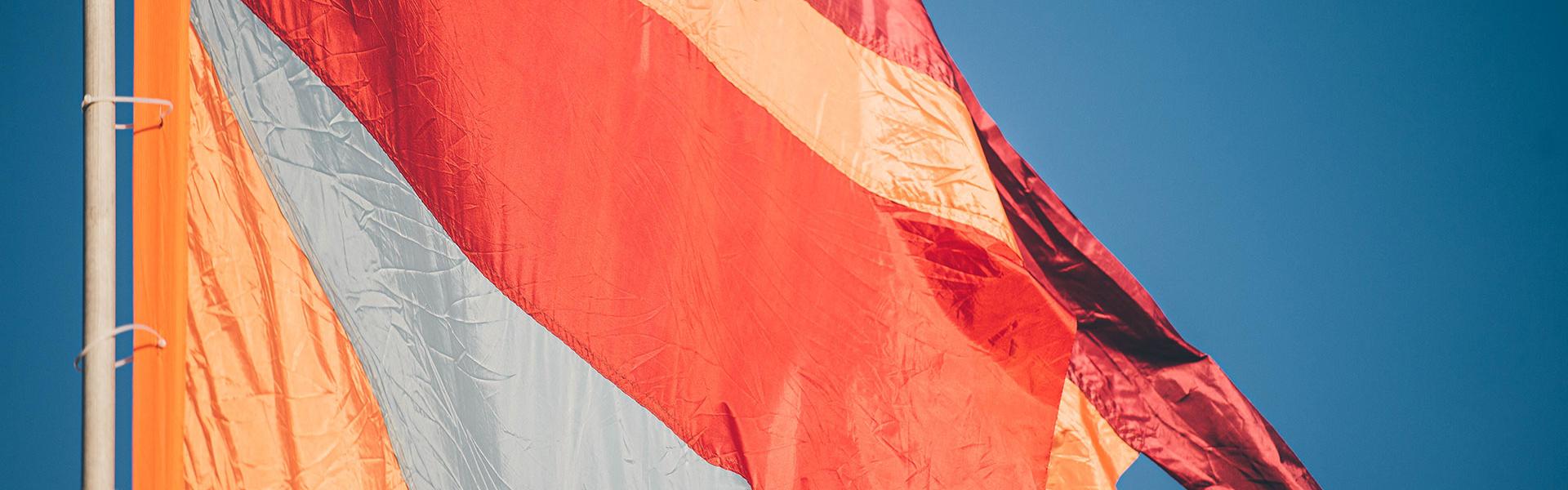 Colourful orange banner against a blue sky