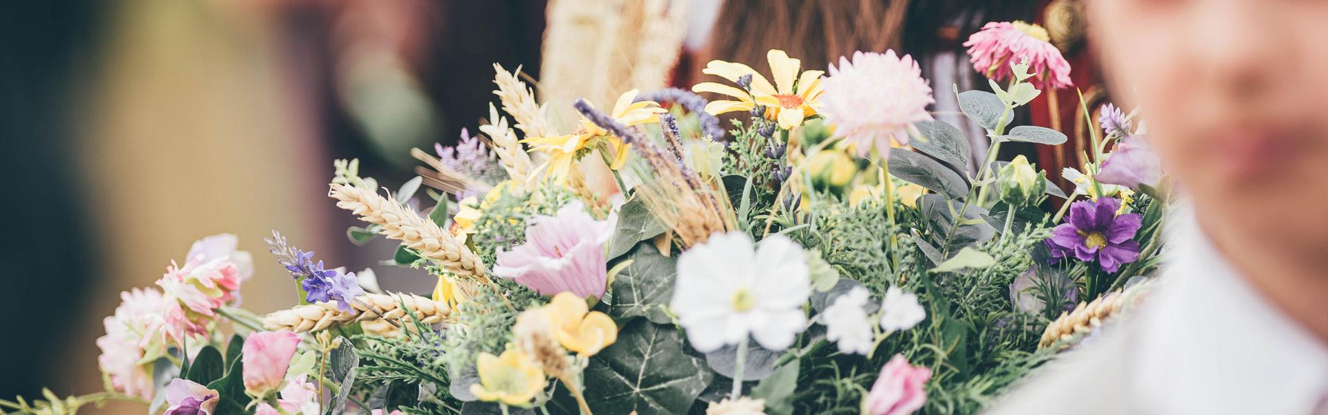 A posy of summer flowers with a young boy standing in the foreground