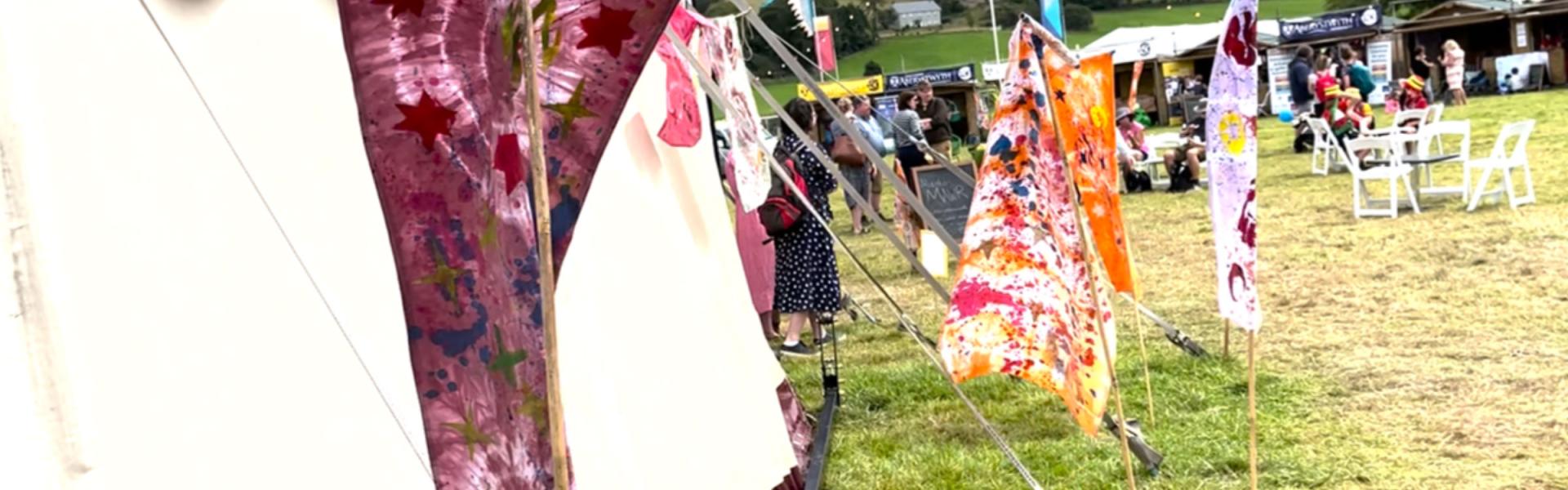 flags and stands in a field with a few people in the picture