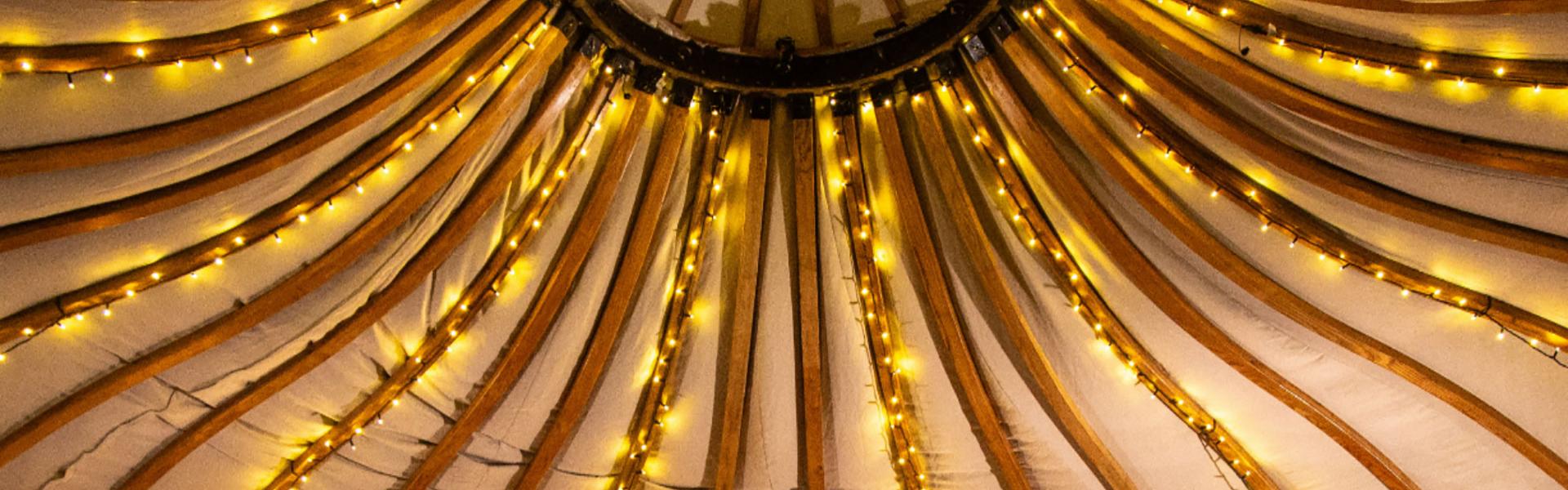 The roof of the Folk House with small lights bright, and a band playing in the evening